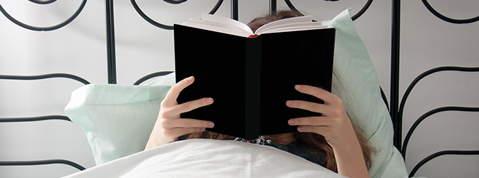 Vrouw leest een boek in bed