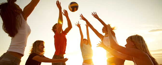 Volleyballen tijdens de ondergaande zon op het strand