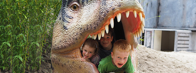 Kinderen in de mond van een dino in Dinoland
