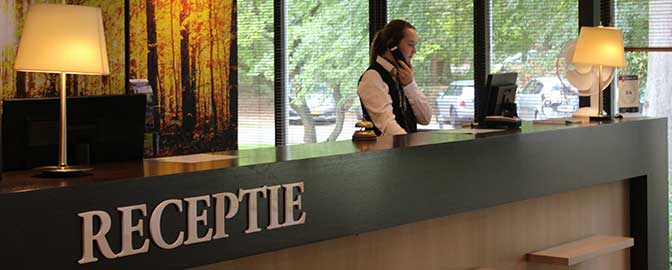 Receptioniste van Fletcher Hotel-Restaurant Amersfoort aan de telefoon