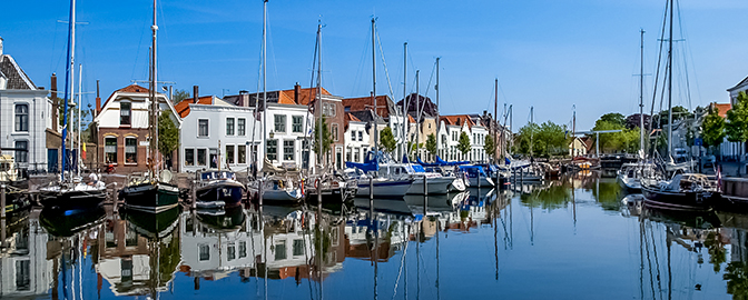 Huizen langs en boten op het water van Middelburg