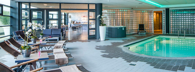 Binnenzwembad en loungestoelen van BLUE Wellness Trivium